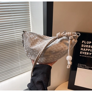 Detail of the unique scale-textured crescent bag with creative knot shoulder strap