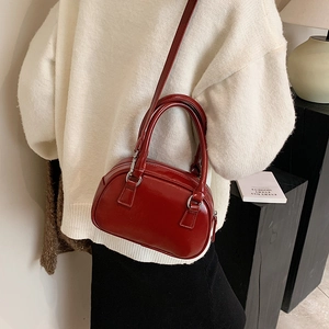 Elegante borsa bowling in vernice rossa con manici e tracolla da donna alla moda