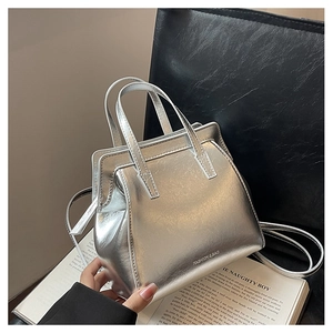 Detail of silver metallic handbag showing smooth texture and adjustable crossbody strap