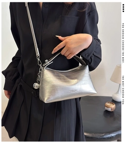 Chic silver metallic bucket bag with textured finish and silver bell charm detail