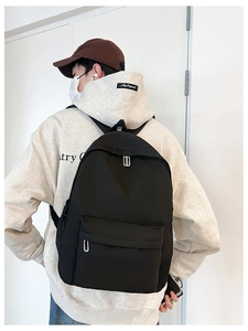 Minimalist black nylon backpack shown on model featuring durable matte finish