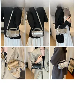 Vues détaillées du sac Boston métallisé en argent et or portées par un mannequin de mode