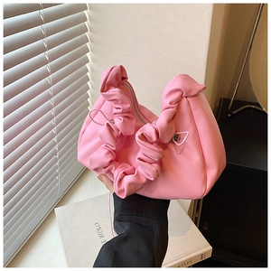 Close-up of pink ruched cloud handbag with silver metal zipper and soft pleated texture