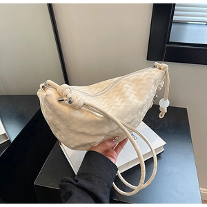 Detail of off-white dumpling bag showing unique wavy pleat texture and bead knot strap
