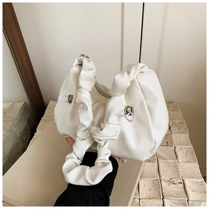 Detail of white pleated cloud bag showing ruched handle and silver hardware zipper