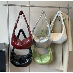 Detail view of glossy hobo bags in five colors including burgundy and emerald green