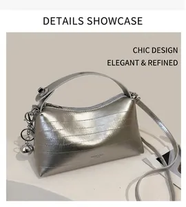 Detail view of silver textured bucket bag with top handle and metallic ball charm