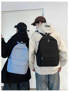 Rear view of high school students wearing lightweight nylon backpacks in black and light blue