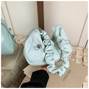 Detail view of mint green ruched handle bag with drawstring and silver hardware