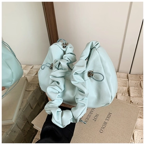 Detailed view of mint green pleated handle and soft matte leather texture on handbag