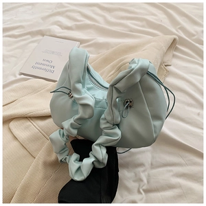 Close-up of mint blue pleated handle handbag with elegant side drawstring and metal buckle