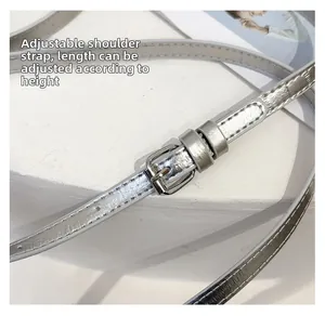 Detail of adjustable silver metallic shoulder strap with fine texture and metal buckle