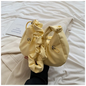 Macro view showing the soft yellow pleated texture and stylish shoulder strap design