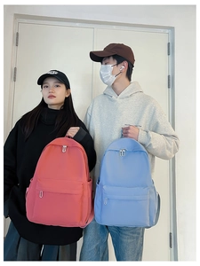 Detailed view of lightweight nylon school backpacks in vibrant red and soft blue colors
