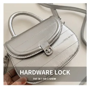 Detail of silver textured leather handbag with a polished metal striped buckle