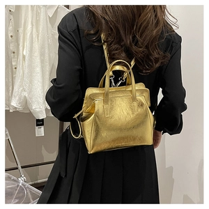 Close-up of a compact gold metallic backpack with pleated PU leather and thin straps