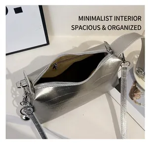 Silver metallic textured handbag featuring a secure zipper closure and a spacious interior