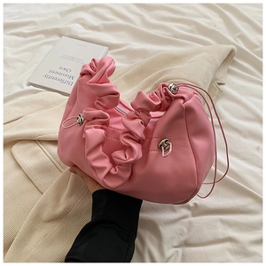 Detailed close-up of soft pleated light pink handbag with silver zipper and slim handle