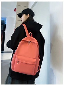 Rear view of coral nylon student backpack with side pocket and zipper compartment