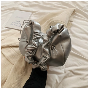 Detail of silver metallic pleated handbag with textured faux leather and drawstring