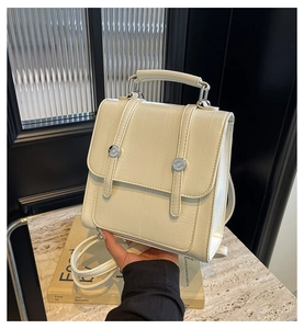 Detail of cream backpack with vertical ribbed leather texture and silver buckle