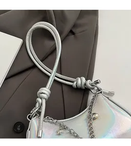 Detail of silver laser leather texture with metallic chain and heart charm