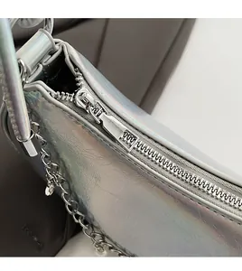 Close-up of durable metal zipper on silver holographic crossbody bag with chain detail