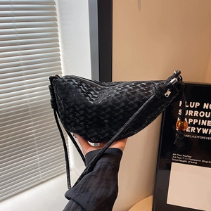 Modern black woven crescent shoulder bag with orange charm and sleek metal zipper