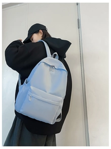 Side view of lightweight light blue nylon backpack on a model in a minimalist setting