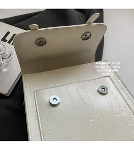 Close-up of magnetic snap closure on textured cream leather casual backpack