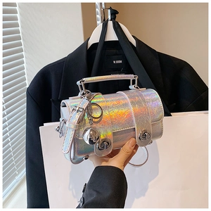 Détail du sac laser argenté avec texture craquelée et pendentif boule métallique
