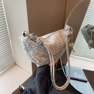 Chic silver crescent bag with wave texture and knotted handle for a modern look