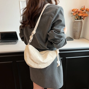 Minimalist beige hobo bag with moon shape and knotted shoulder strap shown on model
