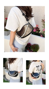 Detail of black glossy patent leather saddle bag with decorative white pearl chain