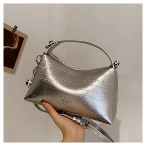 Macro view of silver metallic textured crossbody bag with VESSICO & CHIC branding