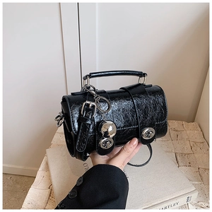 Détail du sac Boston noir en cuir verni plissé avec breloques argentées et boucles