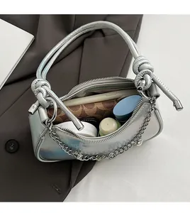 Detail of silver holographic dumpling bag with chain strap and spacious interior