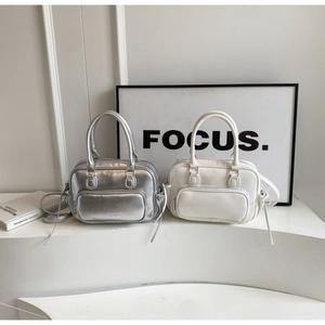 Close-up of stylish Boston bag featuring front zip pocket and sleek metallic silver finish