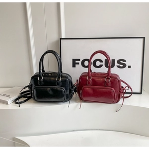 Close-up of retro black and burgundy Boston bags with glossy oil-waxed leather texture