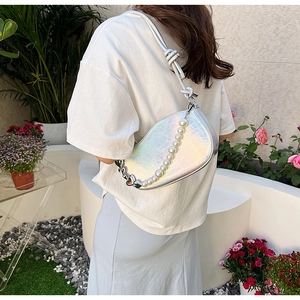 Close-up of iridescent silver saddle bag with pearl chain and knotted shoulder strap
