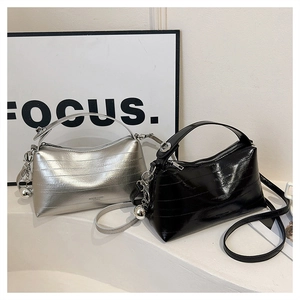 Close-up of textured silver and black bucket bags with pleated finish and silver charms