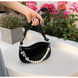 Détail du sac croissant plissé noir avec perles et breloques en forme de cœur argenté
