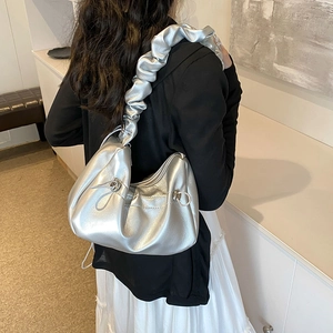 Silver metallic pleated cloud handbag with drawstring strap for women in a side view