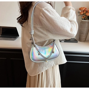 Détail du sac à bandoulière argenté holographique avec sangle nouée et chaîne