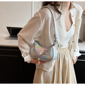 Détail du sac argenté laser avec chaîne métallique, breloque perle et bandoulière nouée