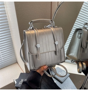 Detail of silver textured leather backpack with vertical stripes and metallic finish