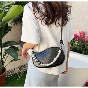 Détail du sac demi-lune en cuir PU noir avec chaîne de perles et breloques en cœur