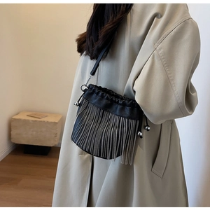 Detail der schwarzen Fransen-Beuteltasche aus Leder mit Kordelzug an einem Model