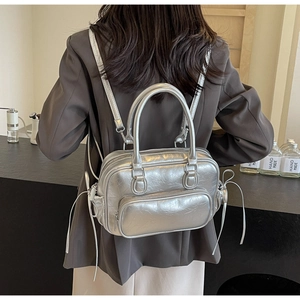 Rear view of silver metallic backpack with glossy wrinkled texture on professional model
