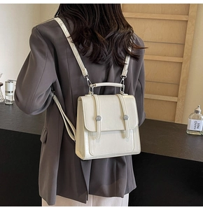Close-up of cream white minimalist backpack with embossed texture and metal buckles